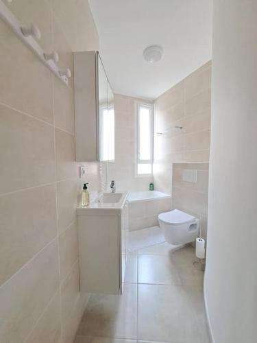 une salle de bain blanche avec un lavabo et des toilettes dans l'établissement Grand T2 Clim & Fibre - centre universités Béziers, à Béziers