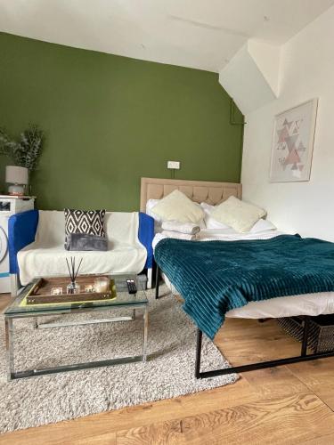 2 camas en una habitación con sofá y mesa en Fulham studio flat en Londres