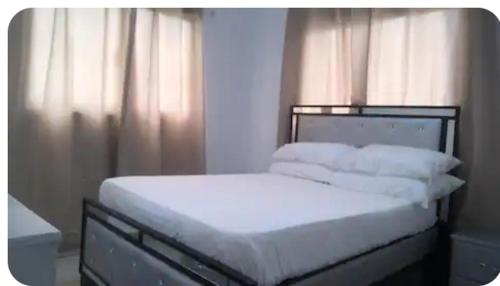 een bed met witte lakens en kussens in een slaapkamer bij Apartamento Bayahíbe nuevo cheisyIII in La Romana