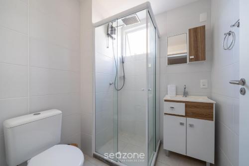 een witte badkamer met een douche en een toilet bij Belo Apto com Vista Mar em Barra Velha VAC2205 in Barra Velha