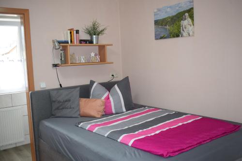 ein Bett mit einer Decke auf dem Zimmer in der Unterkunft Marktstübchen, Einzelzimmer in Bornich