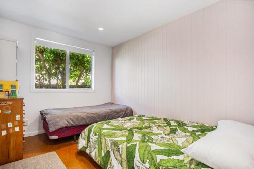 a bedroom with a bed and a window at Waihi Wonder - Waihi Holiday Home in Waihi Beach