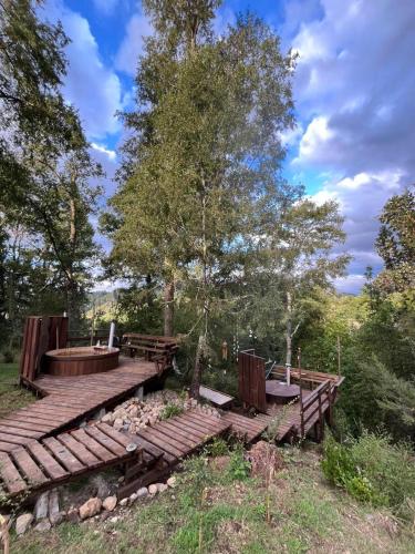 a wooden deck with benches and a tree at Wincarayen Lodge & Cabañas in Panguipulli