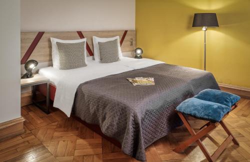 a bedroom with a large bed with a blue blanket at Art House Apartments by Adrez in Prague