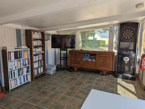 a living room with a tv and book shelves at Camping de Lanven in Plomeur