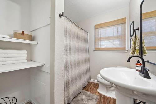 biała łazienka z umywalką i toaletą w obiekcie 3 bedroom 1 bath WiFi Large back yard with BBQ pit w mieście Baytown