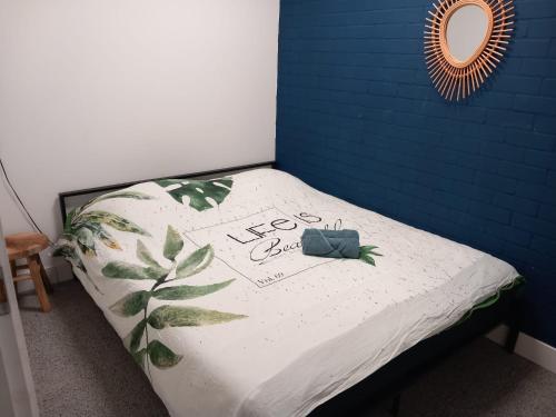 een bed in een kamer met een blauwe muur bij Yerseke Maarten & Hanh in Yerseke