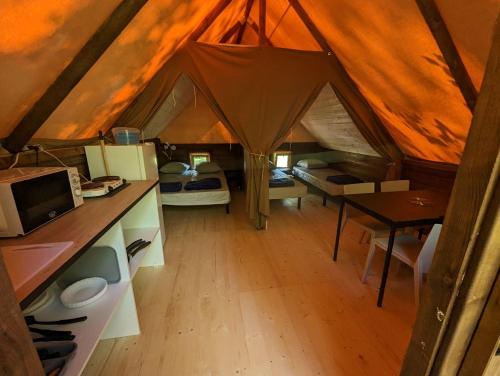 a tent with a kitchen and a table in it at Camping de Lanven in Plomeur