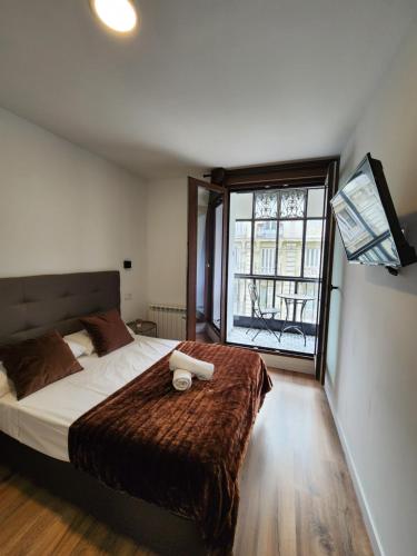 a bedroom with a large bed and a window at Hostal Arenal Madrid in Madrid