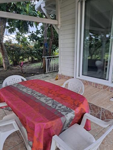 a table and chairs on the porch of a house at Studio à Marie-Galante in Capesterre
