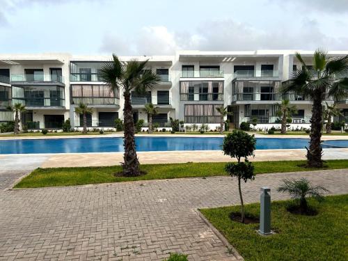 un grande condominio con piscina e palme di Tamaris park a Tamaris