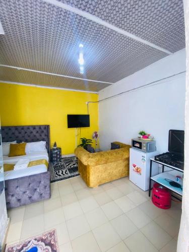 Serenity Studio Nakuru CBD-WiFi-Ample Parking-Netflix-Budget Rates في ناكورو: غرفة نوم بسرير وجدار اصفر