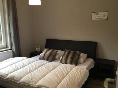 a bedroom with a bed with two pillows on it at vakantiewoning Charme Bohan Sur Semois in Vresse-sur-Semois