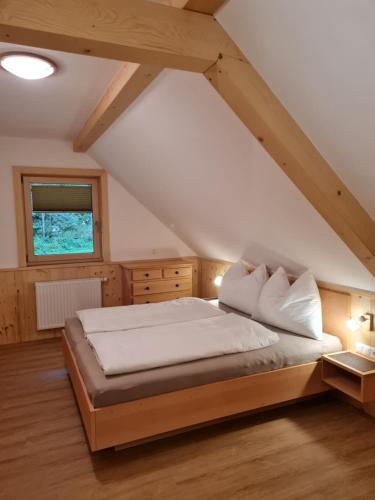 a bedroom with a large bed in a attic at Romantik Chalet Pretalhof in Turnau