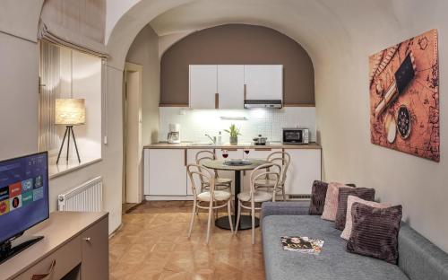 ein Wohnzimmer mit einem Sofa und einem Tisch in der Küche in der Unterkunft 6 Continents Apartments by Adrez in Prag