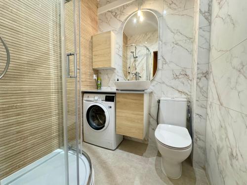 La salle de bains est pourvue de toilettes et d'un lave-linge. dans l'établissement Comfy Apartments - Błękit Gdyni, à Gdynia