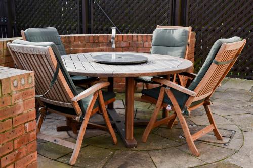una mesa de madera con 4 sillas alrededor en Meadowsweet House, en Stockton-on-Tees