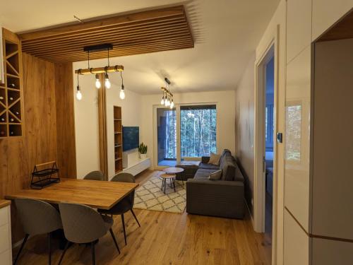 a living room with a table and a couch at Mountain Oasis Bjelasnica in Bjelašnica