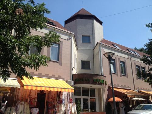 un edificio con una torre de reloj junto a una tienda en Hotel Apart Hotel en Hévíz