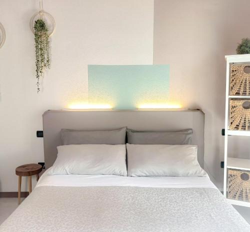 una camera da letto con un letto bianco e luci sopra di esso di Picnic Apartment a Salionze