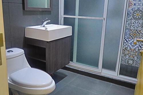 a bathroom with a toilet and a sink and a shower at Villa Casa Encantadora in Retalhuleu