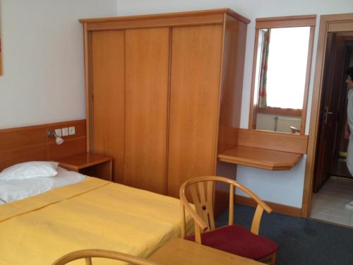 a room with a bed and a table and a window at Hotel Apart Hotel in Hévíz