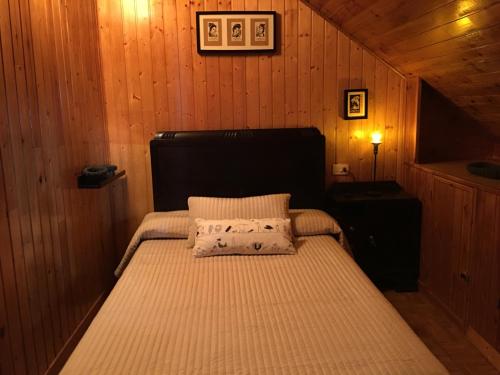 ein Schlafzimmer mit einem Bett in einer Holzhütte in der Unterkunft Apartamento cerca playa 3 in Puentedeume