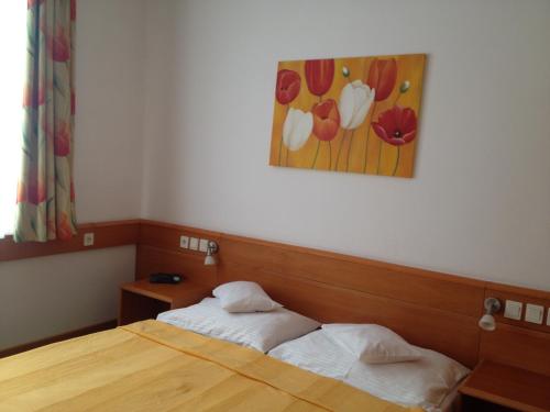 a bedroom with a bed and a painting on the wall at Hotel Apart Hotel in Hévíz