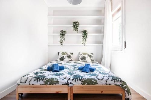 a bedroom with a bed with blue pillows at Newly renovated cozy apartment on a hill in Arenys de Mar