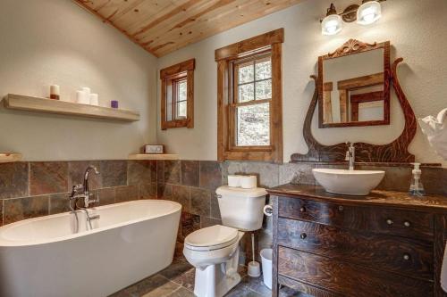 a bathroom with a tub and a toilet and a sink at Wildercreek Cabin in Lead