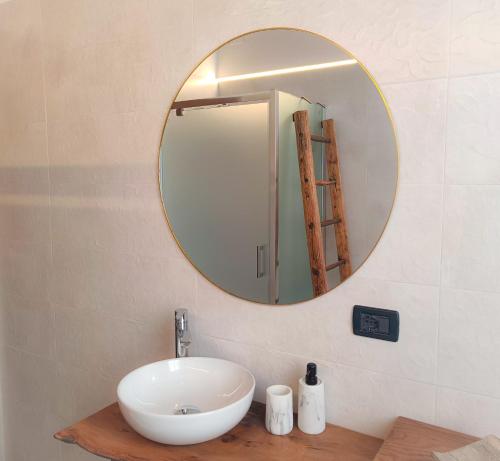 bagno con lavandino bianco e specchio di Picnic Apartment a Salionze