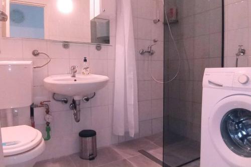 a bathroom with a sink and a washing machine at City Pag Apartment in Pag