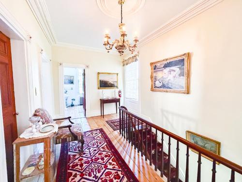 einen Flur mit einer Treppe und einem Kronleuchter in der Unterkunft The Borland House Inn in Montgomery