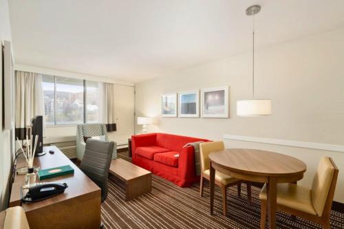 a living room with a red couch and a table at Hôtel 2170 Lincoln Downtown Montreal in Montréal