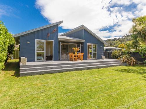 a blue house with a large yard at Waihi Wonder - Waihi Holiday Home in Waihi Beach