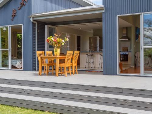 a patio with a table and chairs on a house at Waihi Wonder - Waihi Holiday Home in Waihi Beach