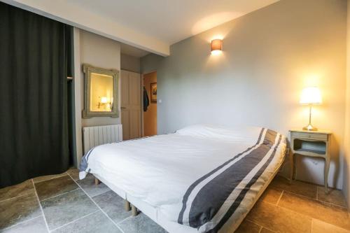 - une chambre avec un lit blanc, une table et une lampe dans l'établissement Villa Lacoste Luberon piscine 4 ch 4 sdb (+ clim), à Lacoste