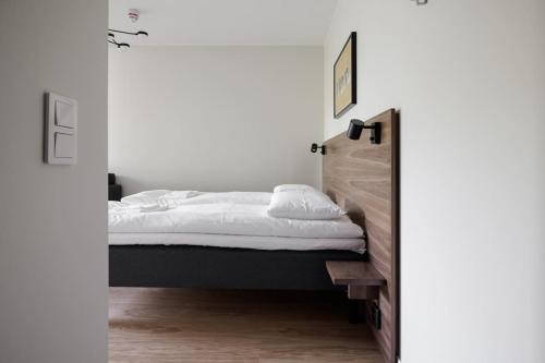 a bedroom with a bed with white sheets at Brand new Studios Amidst Ancient Ruins Oasis in Stockholm