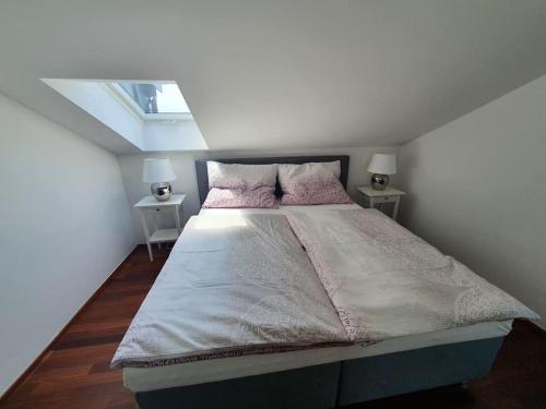 a bedroom with a large bed with two tables at Moderne Ferienwohnung Urlaub am See Mattsee Salzburg Salzburger Seenland Trumer Seenland in Mattsee