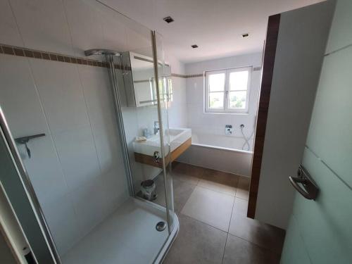 ein Bad mit einer Dusche und einem Waschbecken in der Unterkunft Moderne Ferienwohnung Bestlage in Mattsee Salzburg Salzburger Seenland Urlaub am See in Mattsee