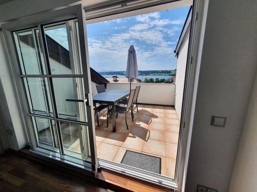 a view of a balcony with a table and umbrella at Moderne Ferienwohnung Urlaub am See Mattsee Salzburg Salzburger Seenland Trumer Seenland in Mattsee
