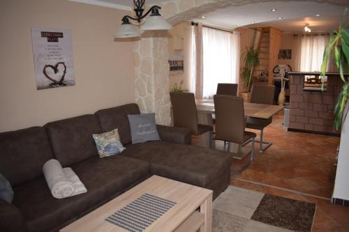 ein Wohnzimmer mit einem braunen Sofa und einem Tisch in der Unterkunft Marktstübchen an der schönen Loreley in Bornich