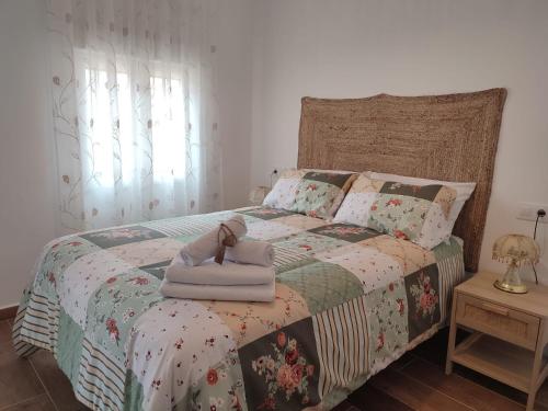a bedroom with a bed with a doll on it at Alojamiento Turístico La Cantuérgana in San Martín de Montalbán