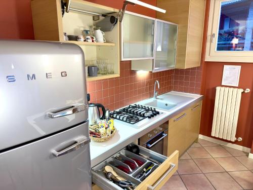 a kitchen with a refrigerator and a sink at In centro a due passi dal lago in Iseo