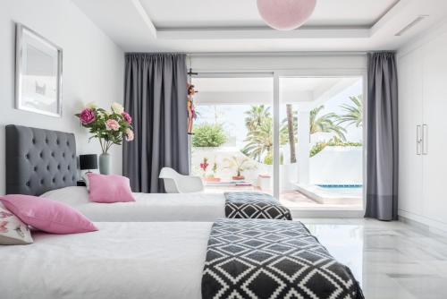 ein Schlafzimmer mit zwei Betten und einem großen Fenster in der Unterkunft OASIS Beachfront Golden Mile in Marbella