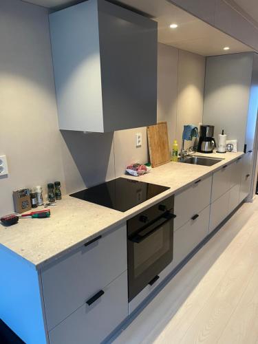 una cucina con mobili bianchi e un piano di lavoro di Hyt leilighet med 2 soverom a Bjorli