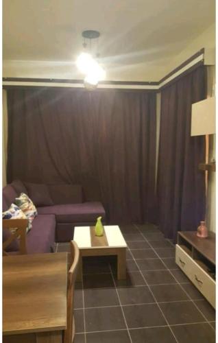 a living room with a purple couch and a table at Duplex apartment in Porto Sharm El skeikh in Sharm El Sheikh