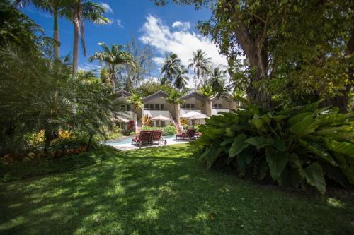 a yard with palm trees and a house at Colony Club, a Luxury Collection Resort, Barbados in Saint James