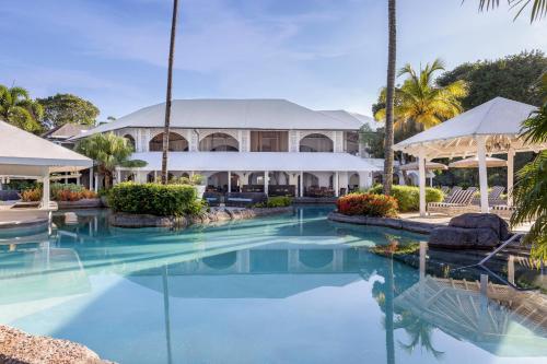 a resort swimming pool with a building in the background at Colony Club, a Luxury Collection Resort, Barbados in Saint James