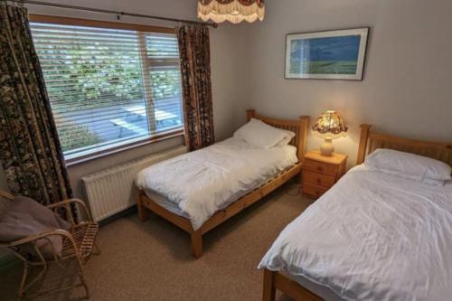 凱爾西溫的住宿－Gurranebawn, Cahersiveen，一间卧室设有两张单人床和一个窗户。
